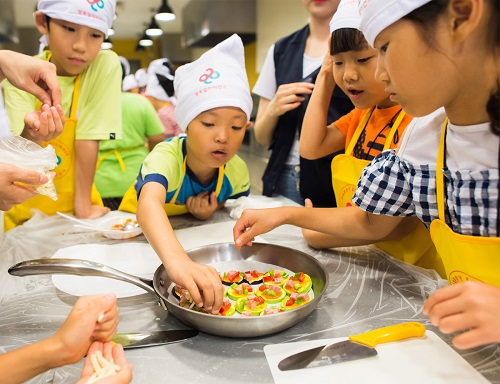 (좌) 행복얼라이언스 건강플러스 캠프에 참가한 아이들이 직접 요리를 만들며 식재료와 친해지는 시간을 갖고 있다. (사진=행복얼라이언스 제공)