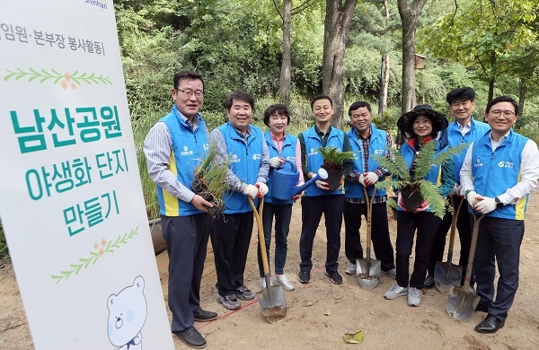 25일 남산공원 야외식물원에서 신한은행 임원봉사단이 야생화 단지조성 봉사활동을 진행하고 있는 모습(사진=신한은행 제공)
