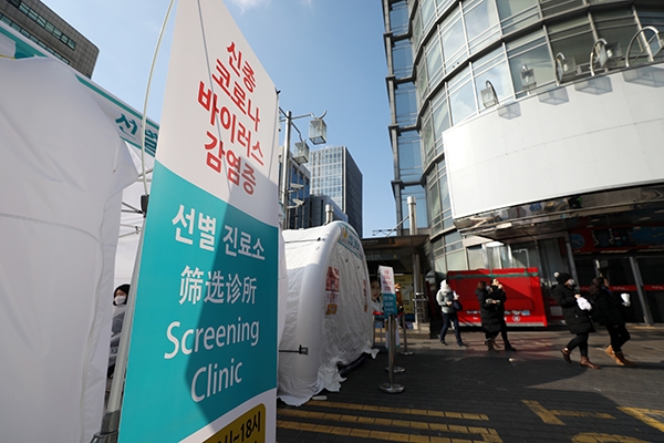 3일 서울 명동역 앞에 설치된 신종 코로나바이러스 감염증(우한 폐렴) 선별 진료소 앞을 관광객들이 지나고 있다. (사진= 뉴시스)