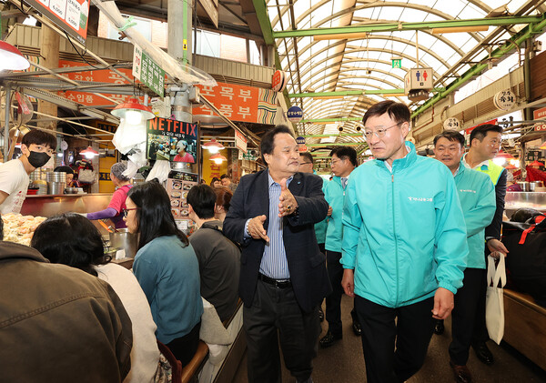 3일 오전 이승열 하나은행장(사진 오른쪽)이 서울 광장시장에서 한 시장 상인으로부터 과거와 달라진 시장 여건에 대한 이야기를 듣고 있다.