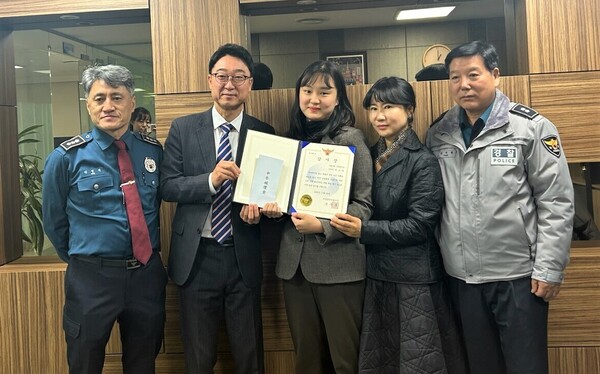 보이스피싱 피해를 예방한 사당역지점 이소라 행원(왼쪽 세 번째)이 서울동작경찰서로부터 감사장을 받고 관계자들과 기념촬영을 하는 모습.